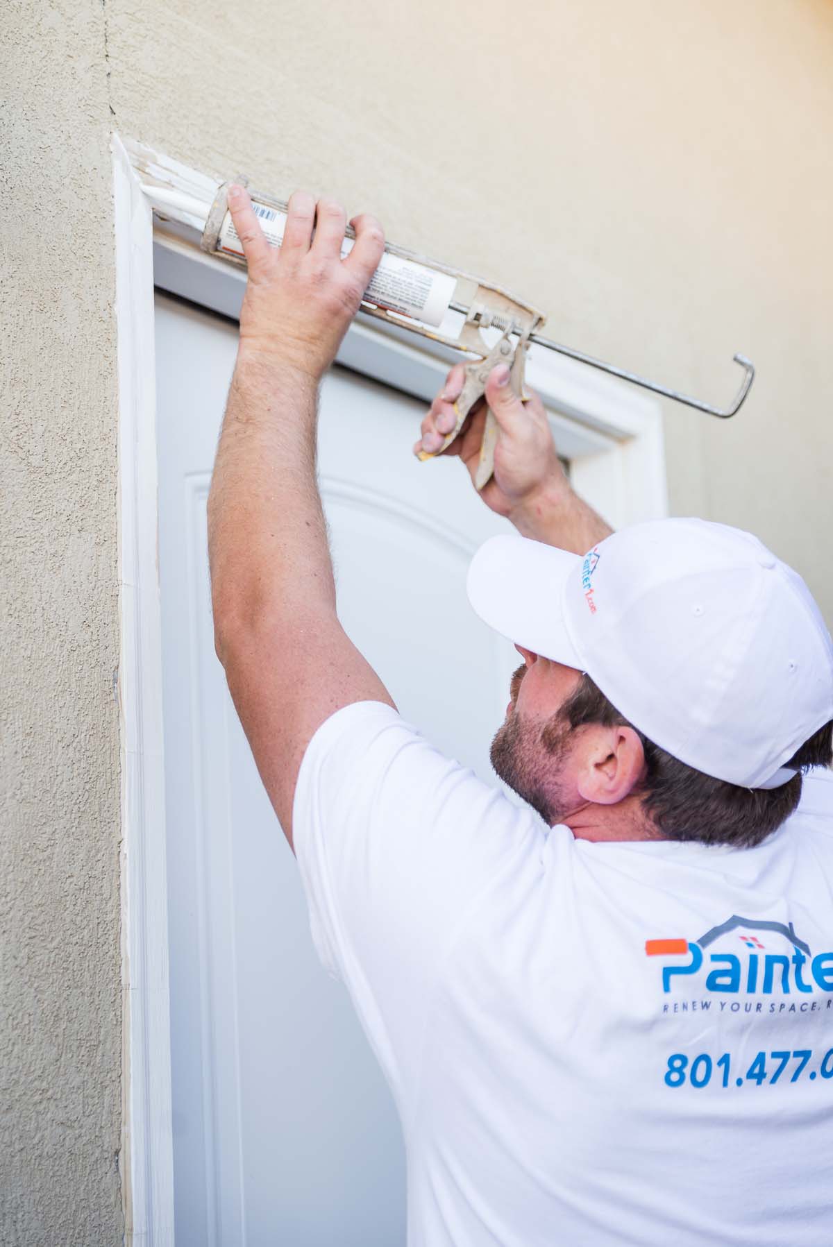 This professional at Painter1 takes care of the detailing around a door - contact us for the precise services your business needs.