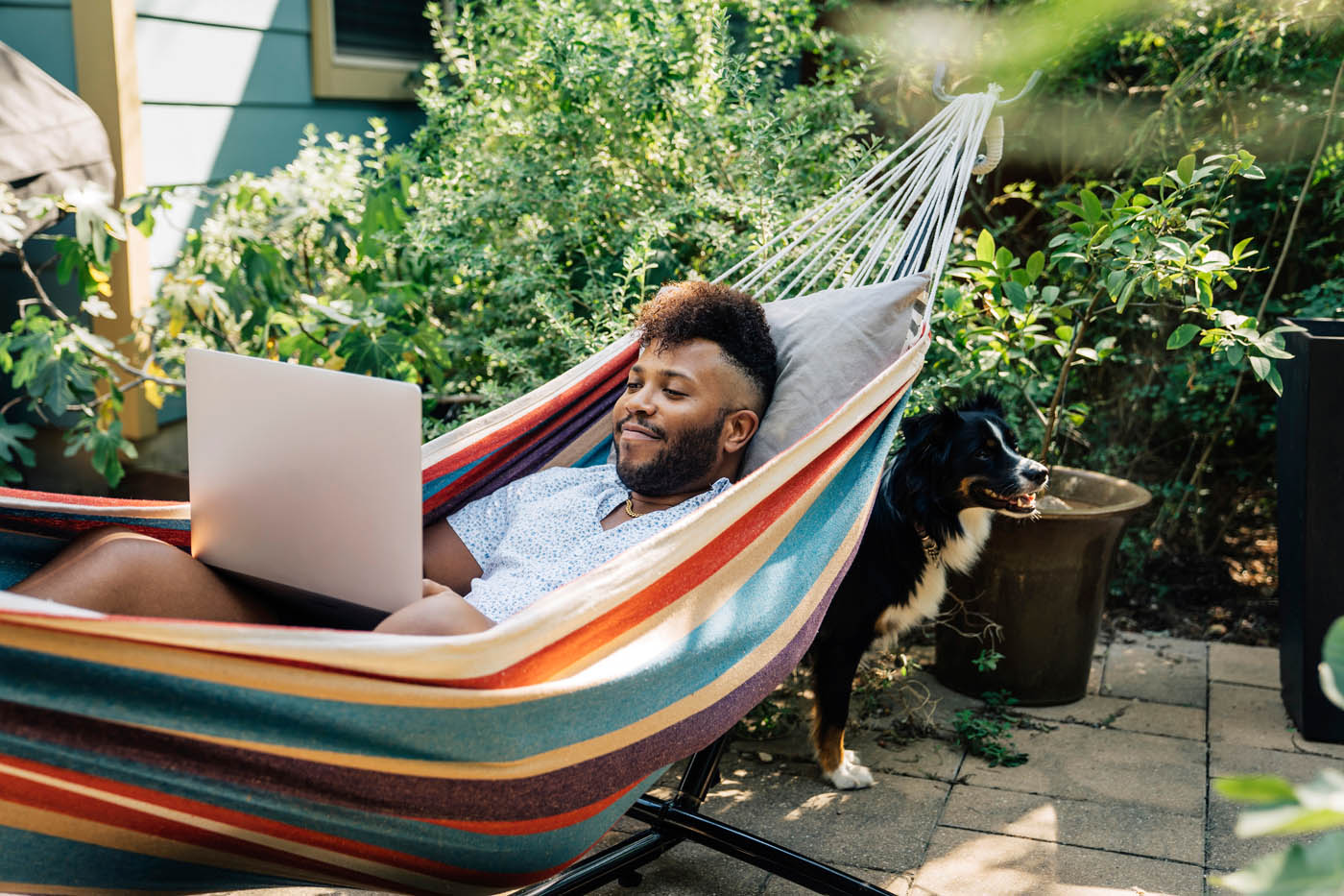 A man relaxing in his hammock outdoors - Rest Easy Pest Control provides expert insect control to keep your spaces pest-free.